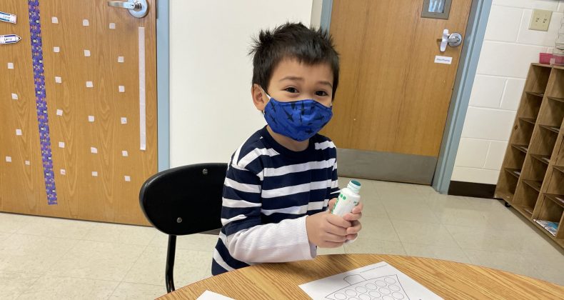 young student with mask on and with art supplies