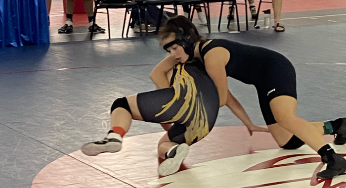 Washington girl's wrestler works to pin her opponent.