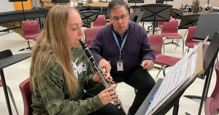 Jefferson's band director works with student.