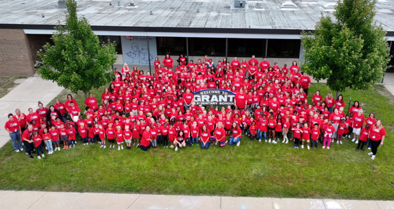 All Grant Students in front of the school sign