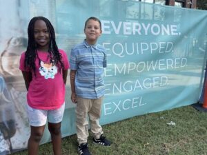 two students standing in front of the cedar rapids community school district banner at Harrison Groundbreaking