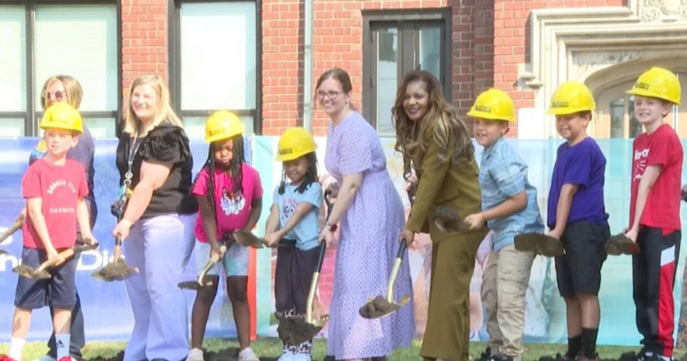 Harrison elementary staff and students standing on dirt for groundbreaking ceremony