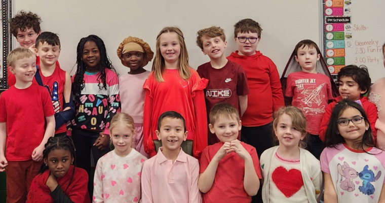 A group of student pose for a picture. The students are wearing red shirts because of Valentines Day.