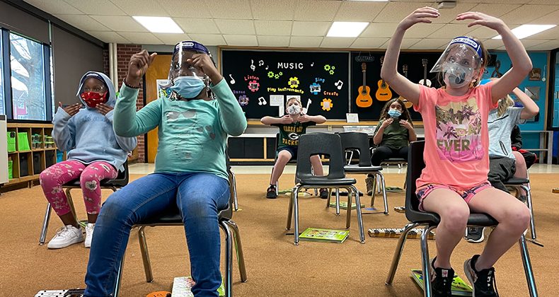 students wearing face coverings in music class