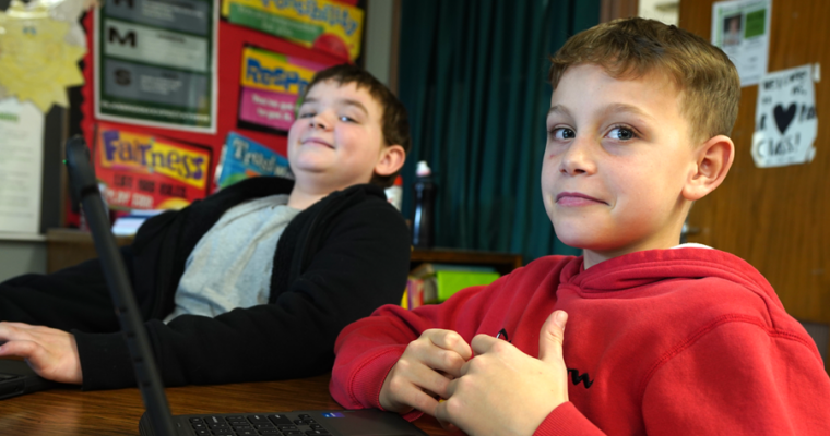 Two Harding students look at the camera and smile about their learning.