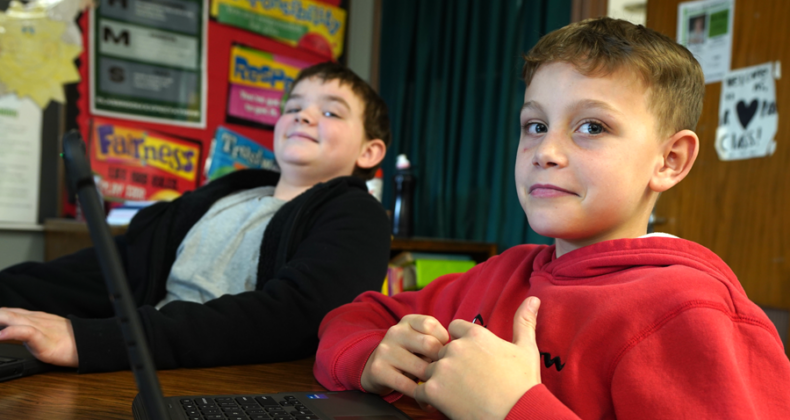 Two Harding students look at the camera and smile about their learning.