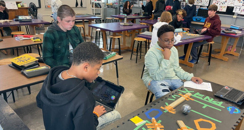 Students in class using coding to move ball through course